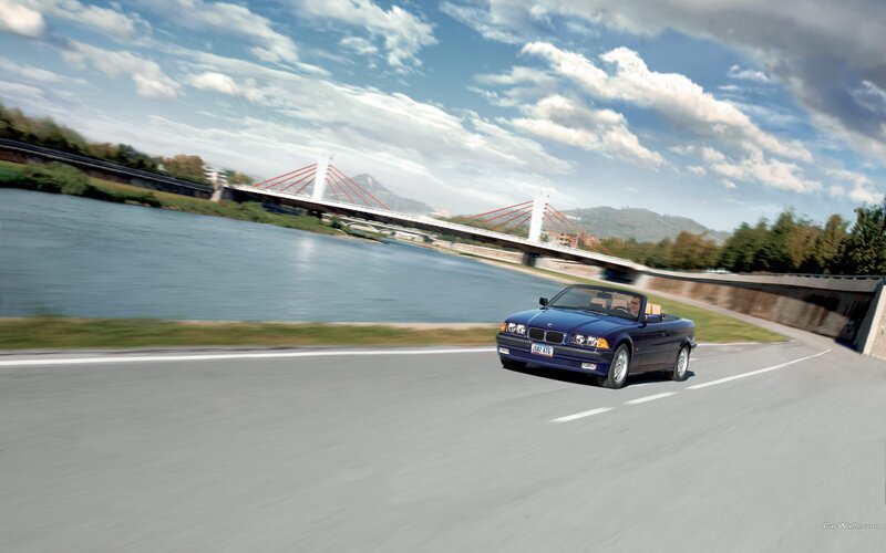 Blue BMW convertible on a scenic road