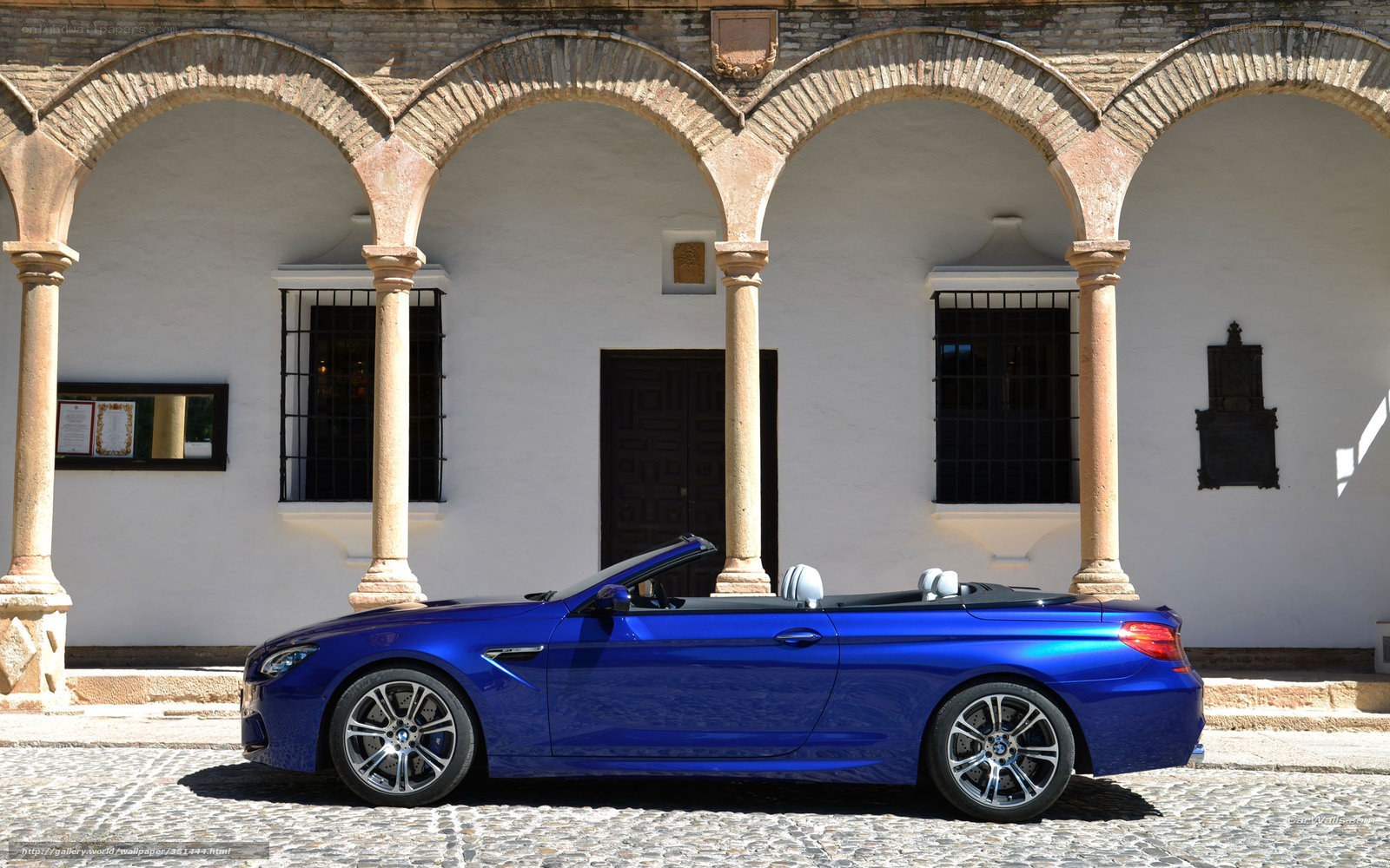 Blue BMW convertible on cobblestone