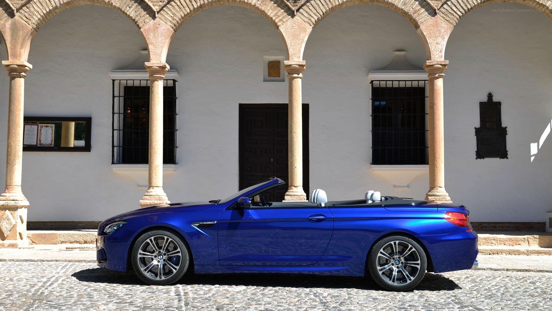 Blue BMW convertible on cobblestones