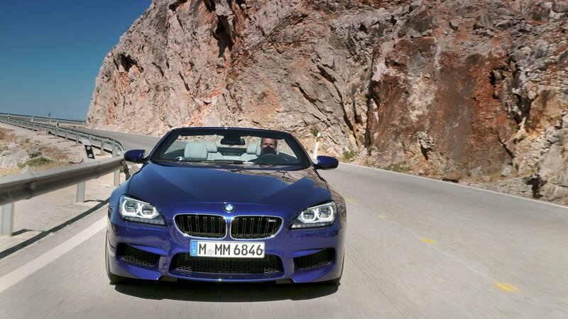 Blue BMW convertible on mountain road