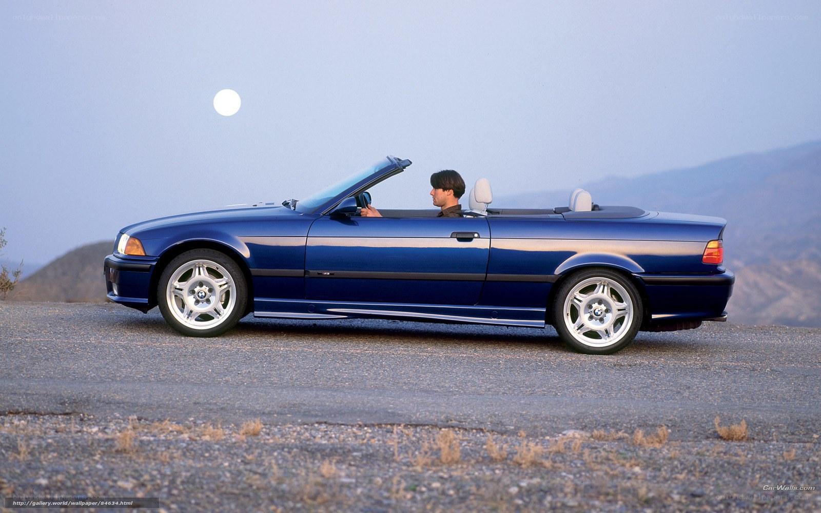 Blue BMW convertible on mountain road