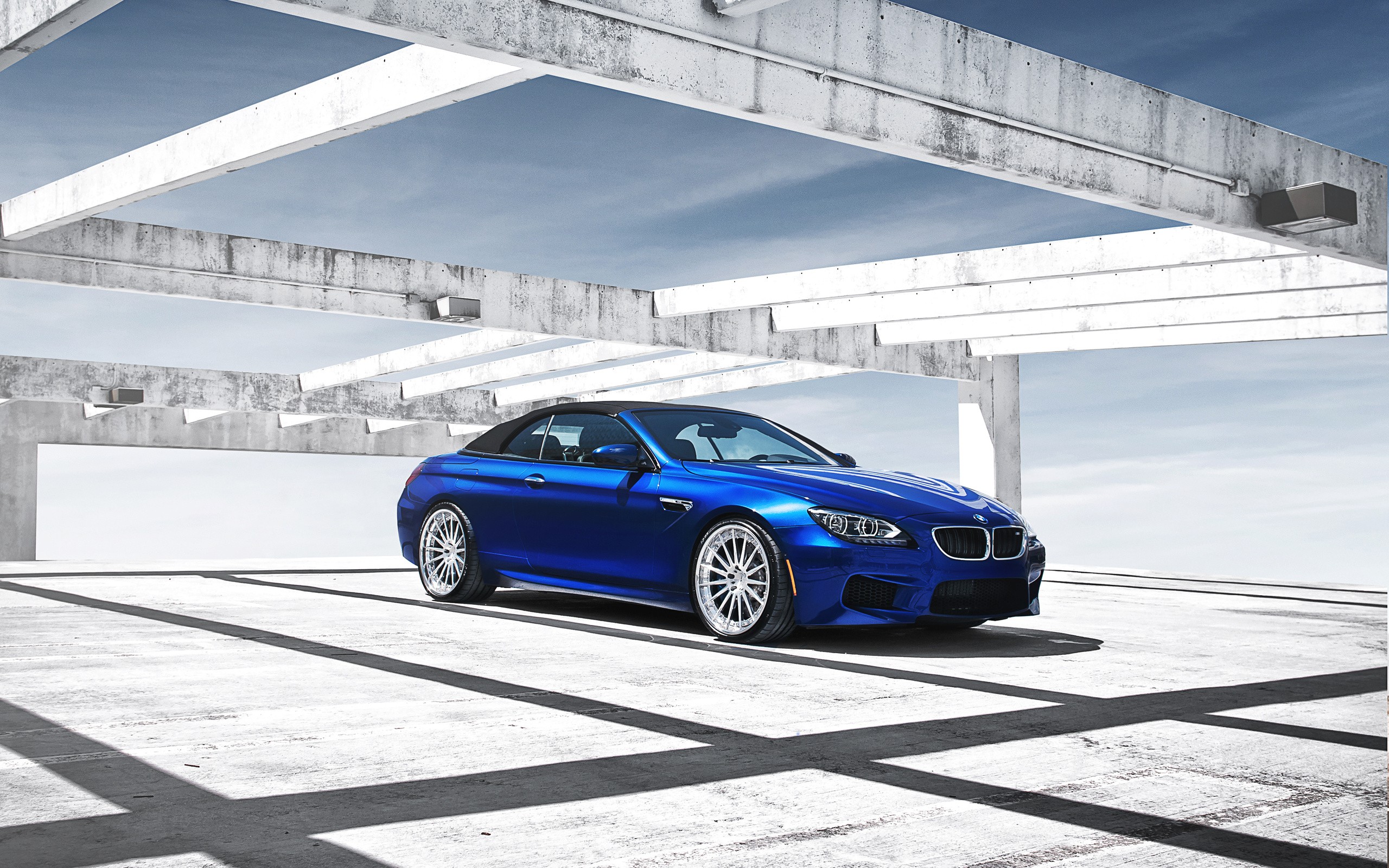 Blue BMW convertible under concrete structure