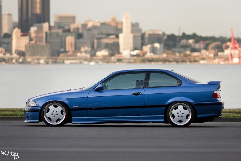Blue BMW coupe by the water