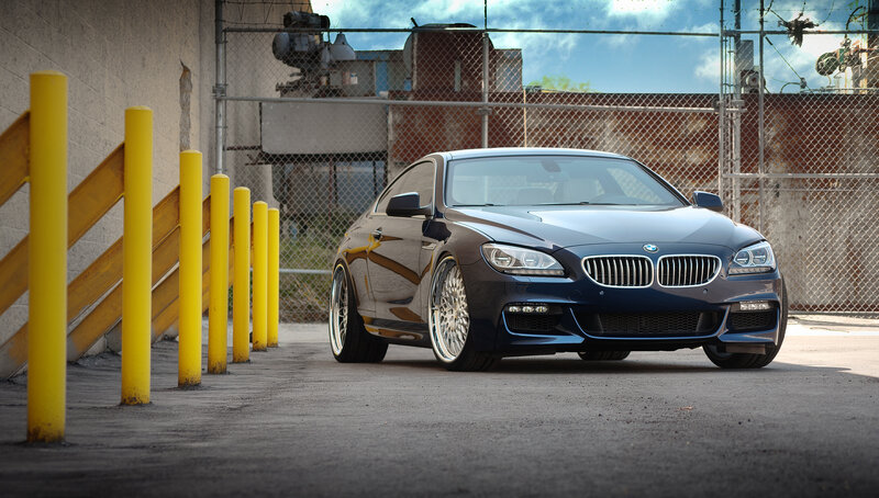 Blue BMW coupe in industrial lot