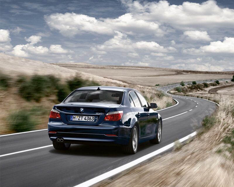 Blue BMW driving on a country road