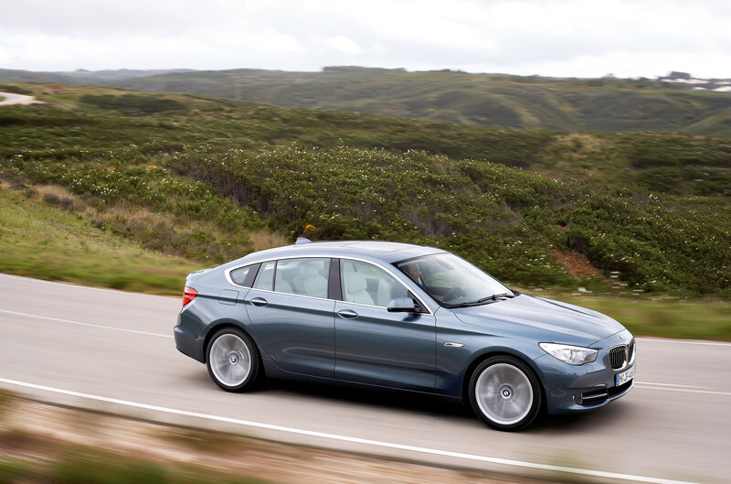 Blue BMW driving on a road