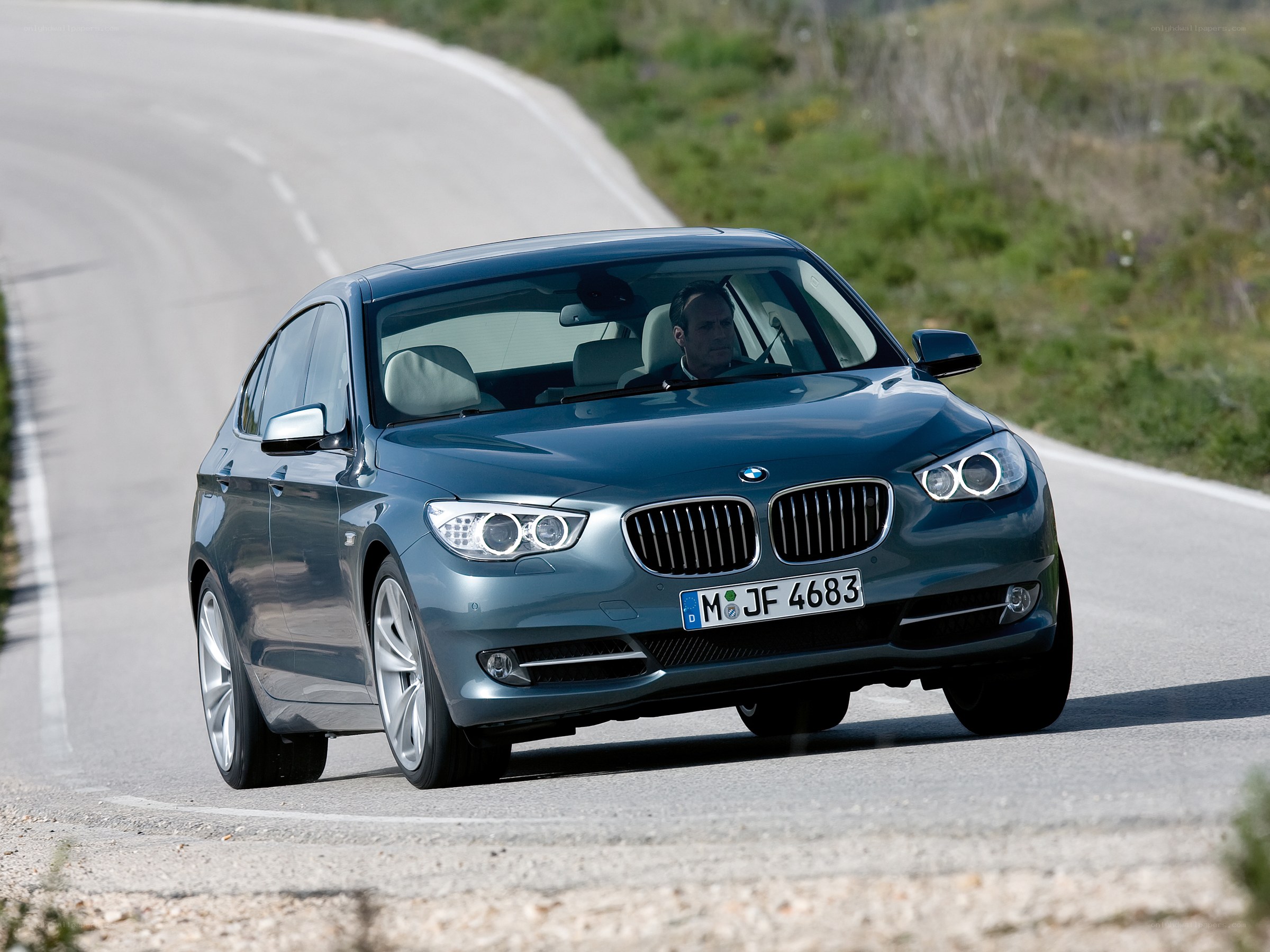 Blue BMW driving on a road