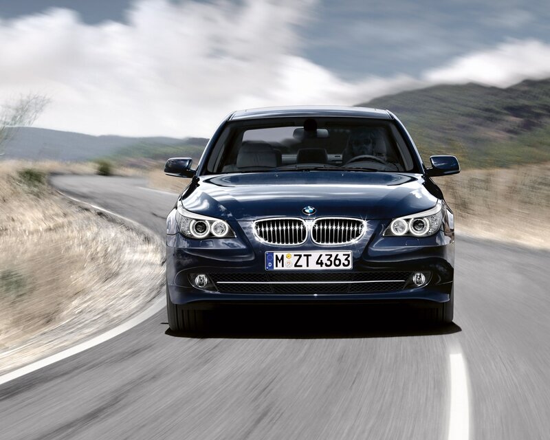 Blue BMW driving on a road
