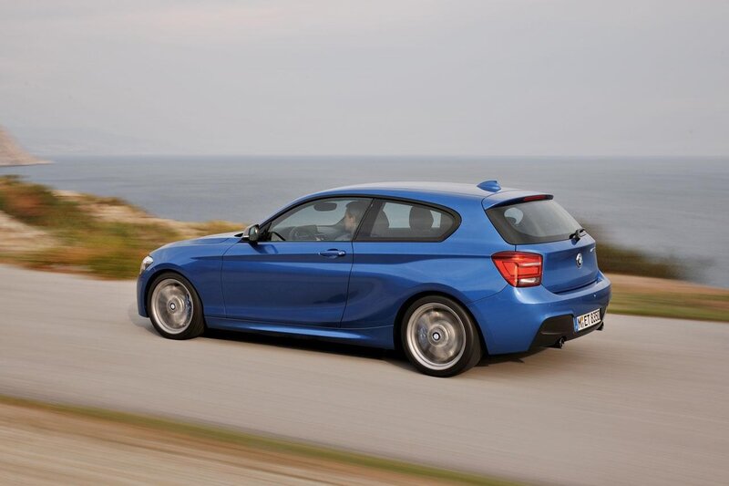 blue bmw driving on coastal road