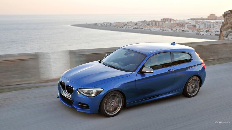 blue bmw driving on coastal road
