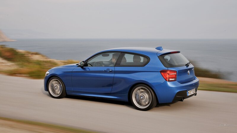blue bmw driving on coastal road