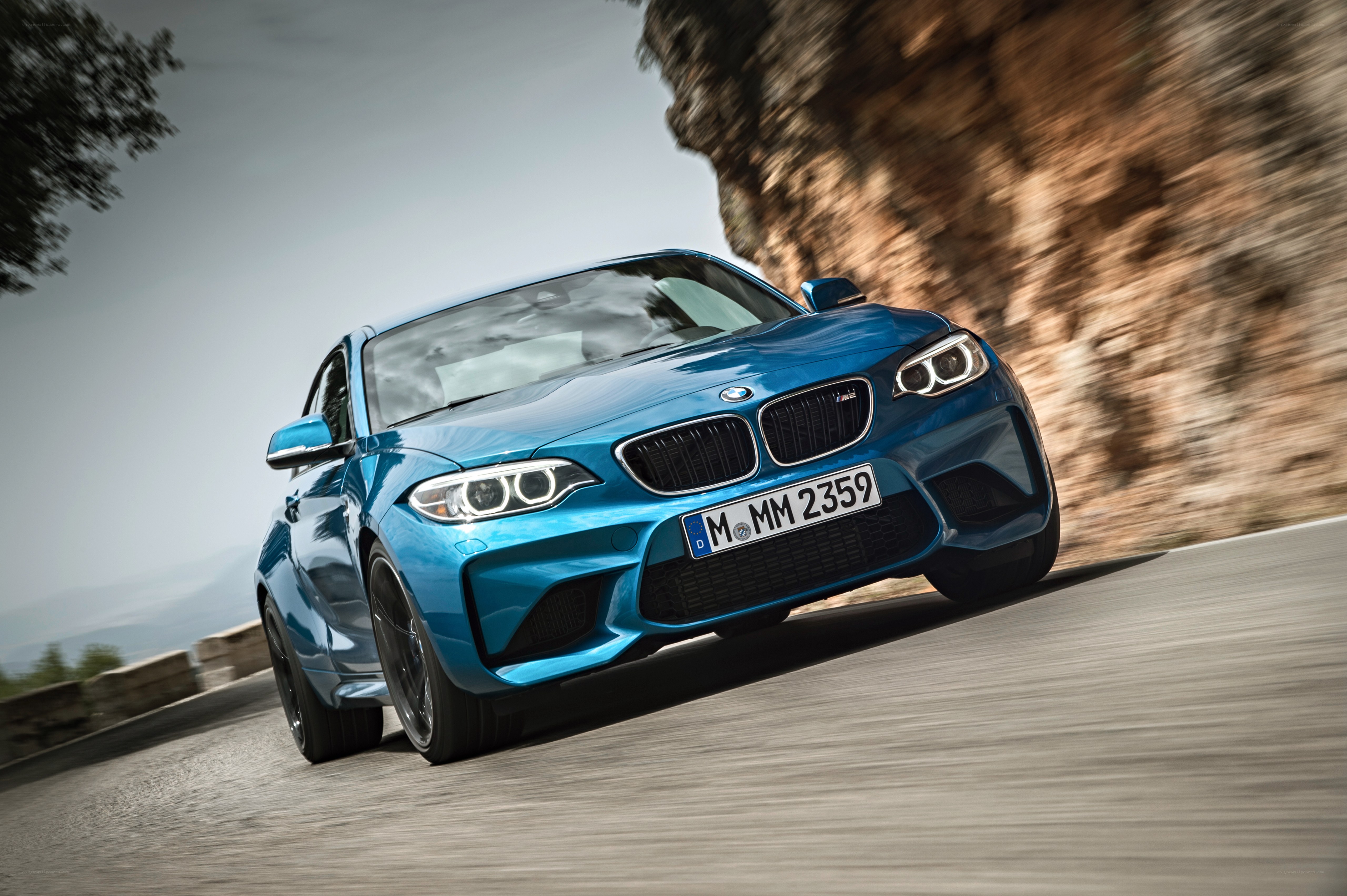 blue bmw m2 driving on road