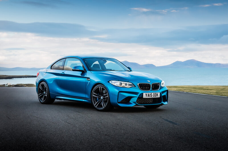 Blue BMW M2 on coastal road