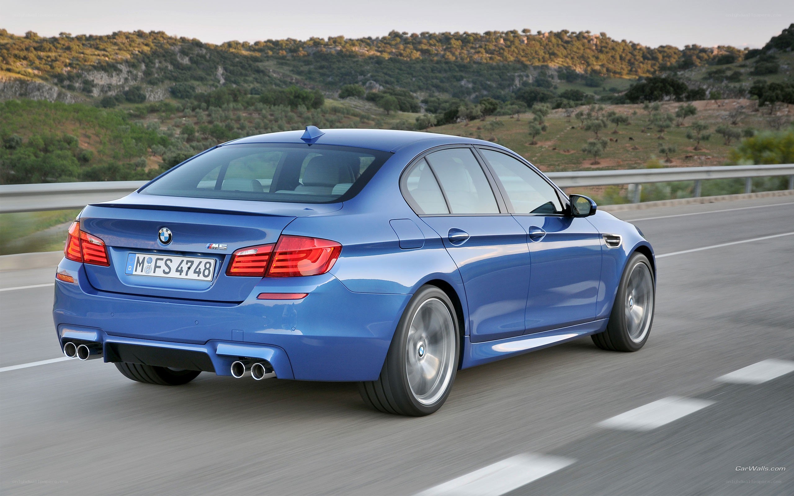 blue bmw m5 driving on road