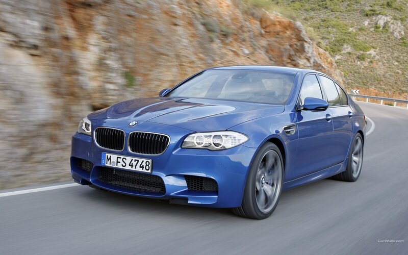 blue bmw m5 driving on road