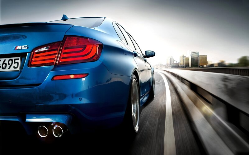 Blue BMW M5 on a city highway