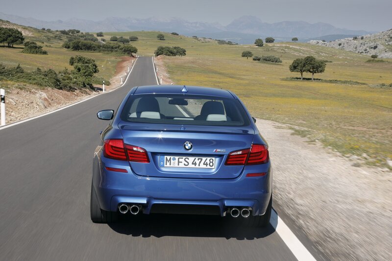 Blue BMW M5 on a country road