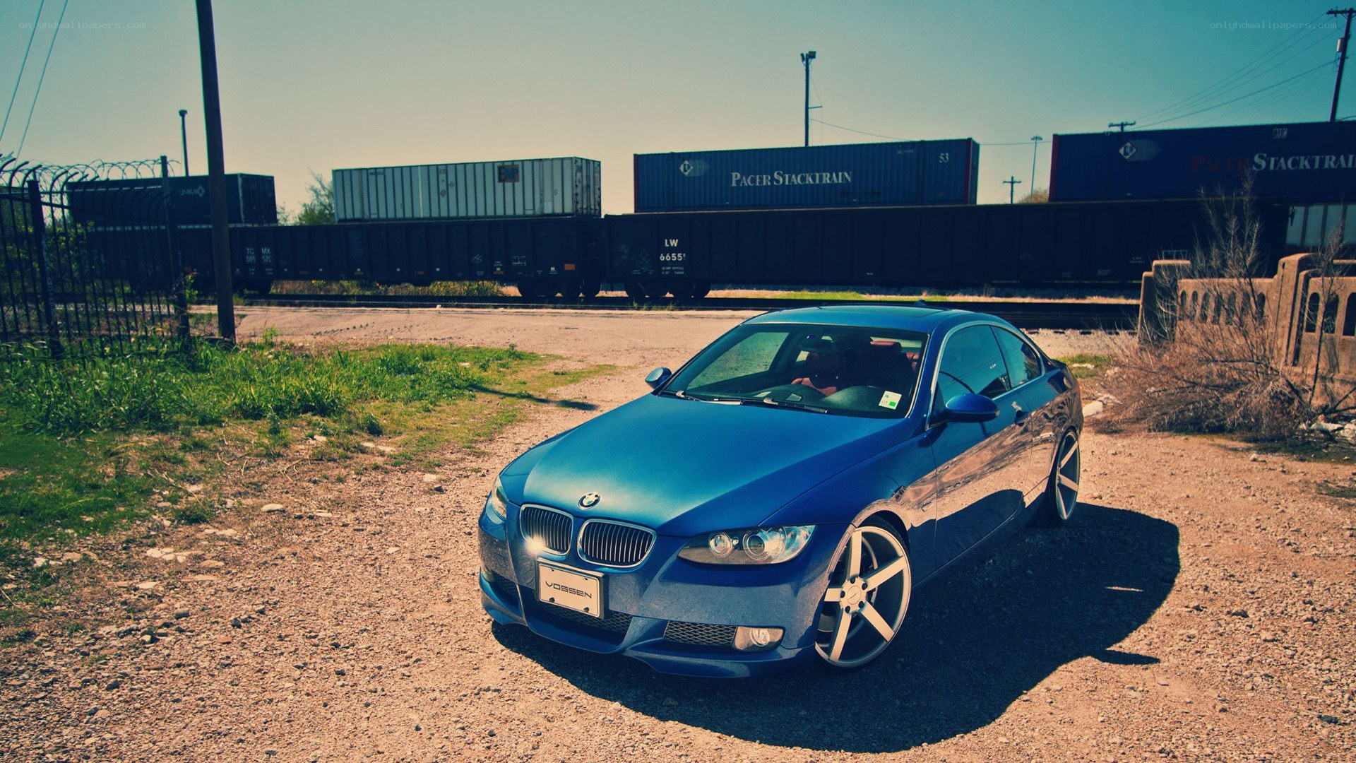 blue bmw near train tracks
