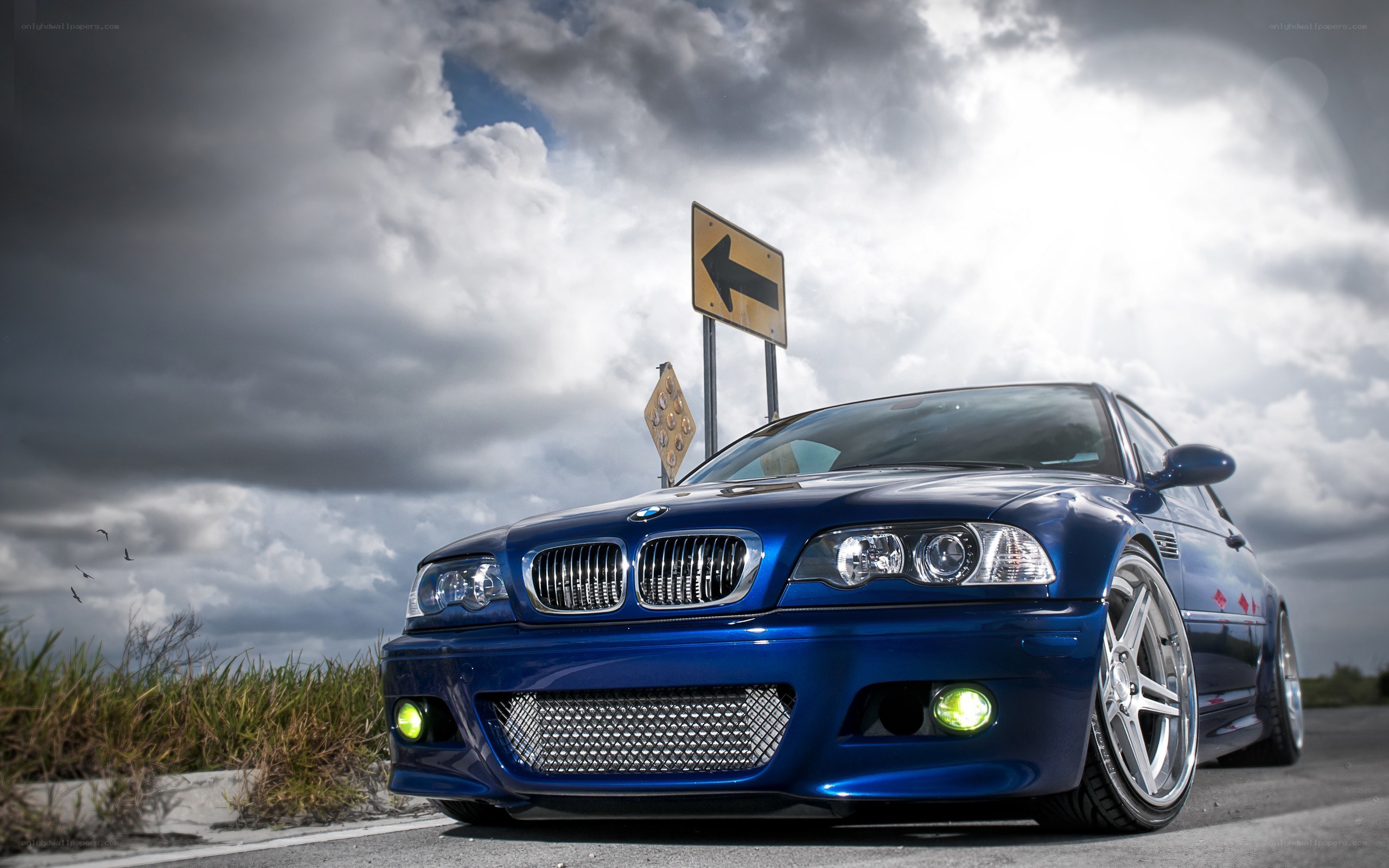 Blue BMW on a cloudy road