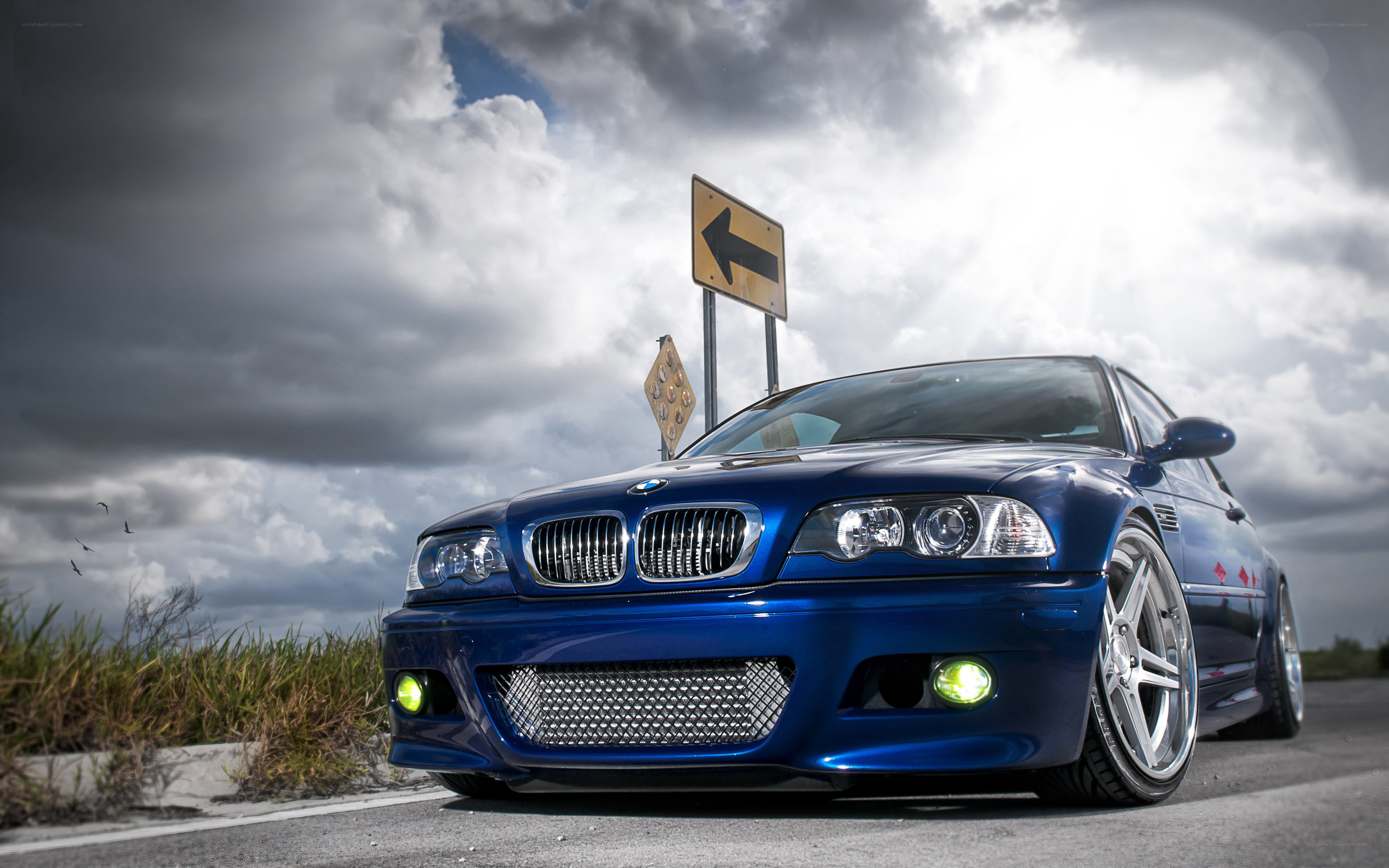 Blue BMW on a cloudy road