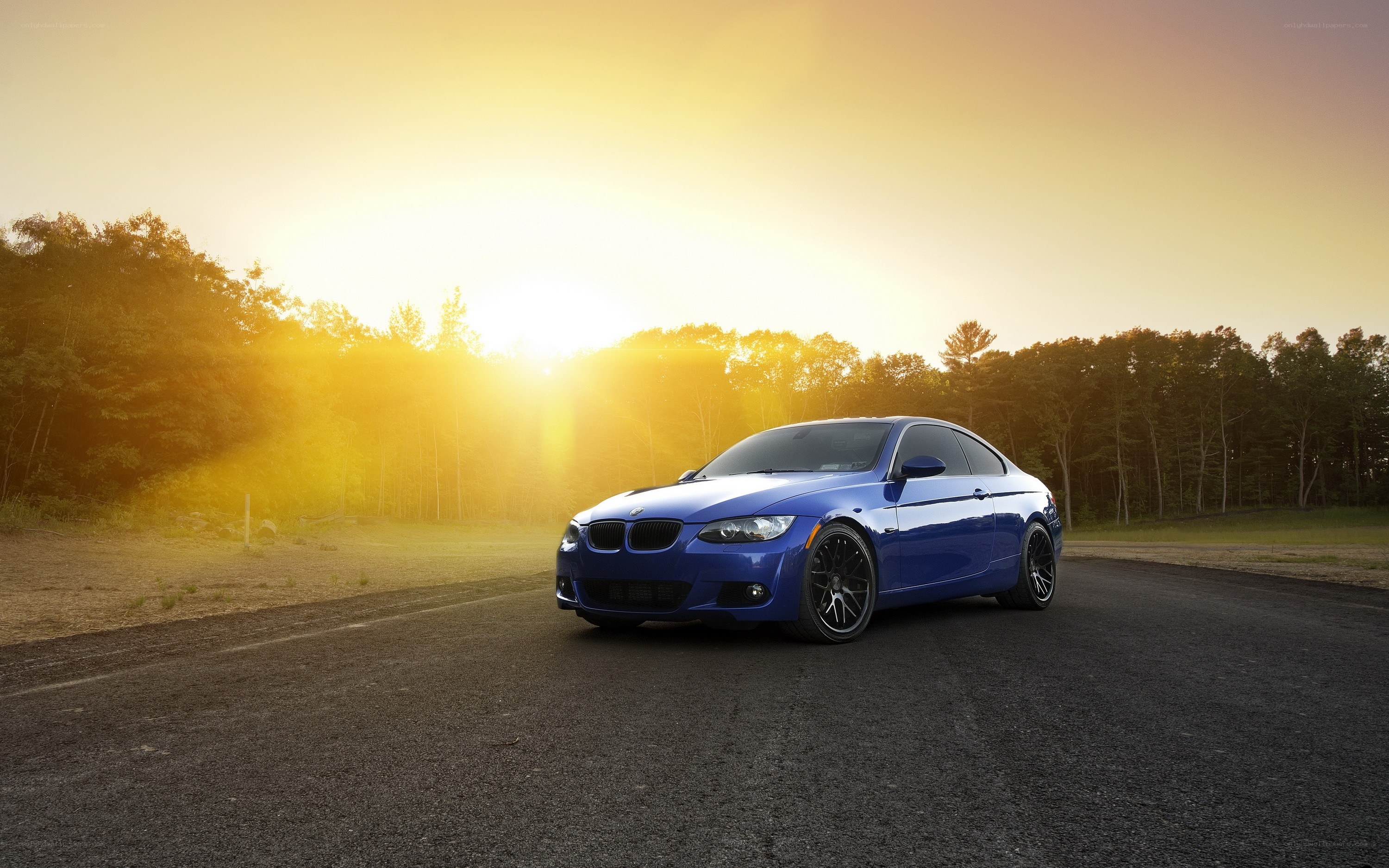 blue bmw on road at sunset