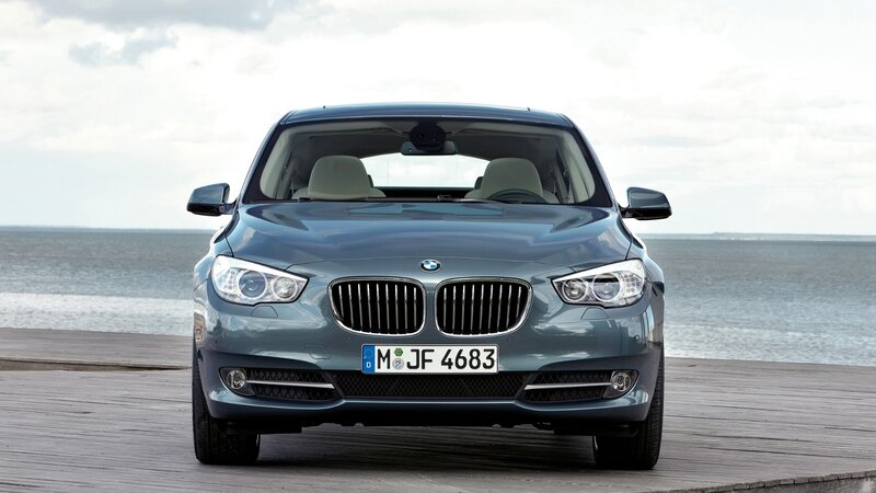 Blue BMW parked by the sea