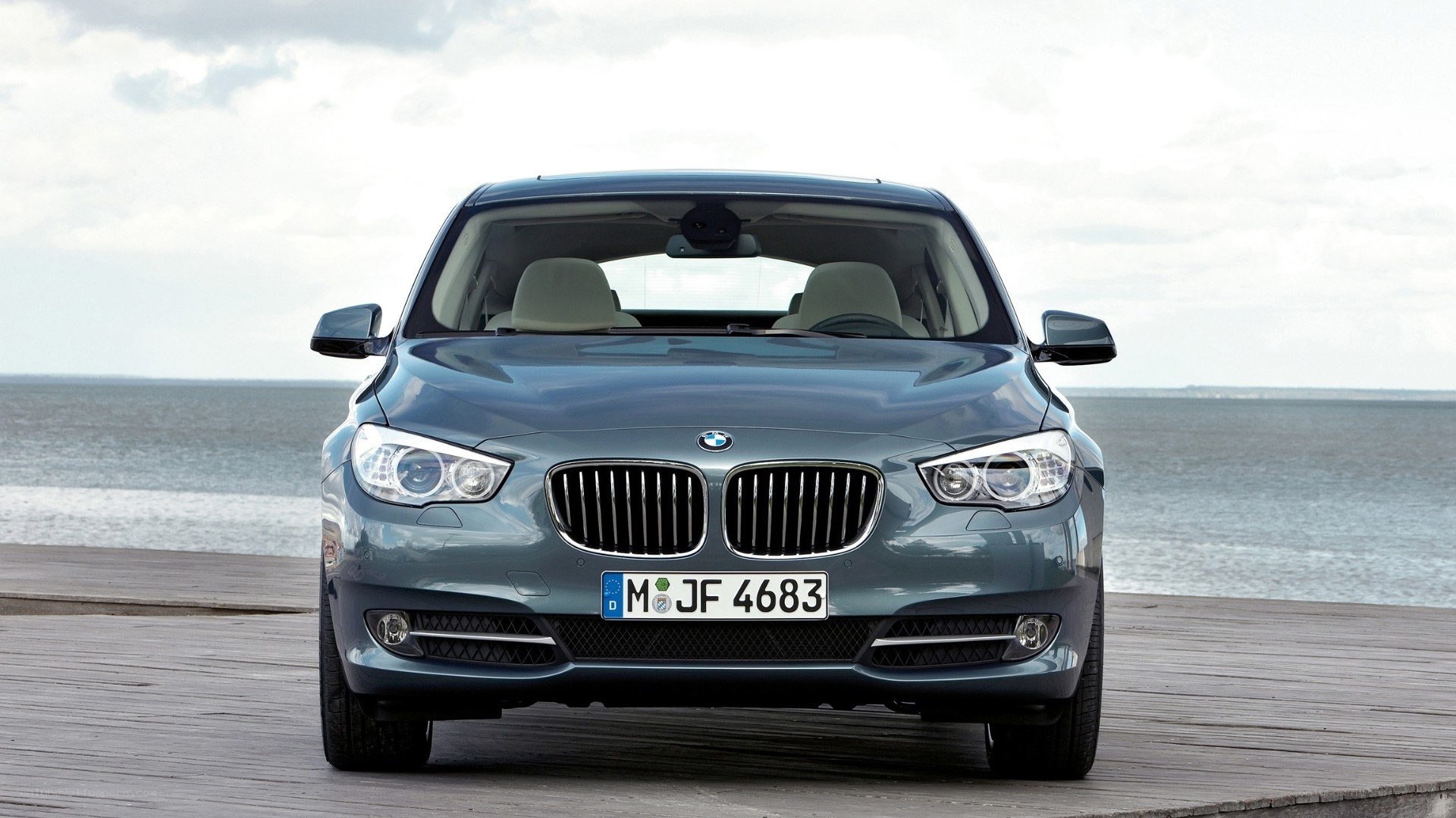 Blue BMW parked by the sea