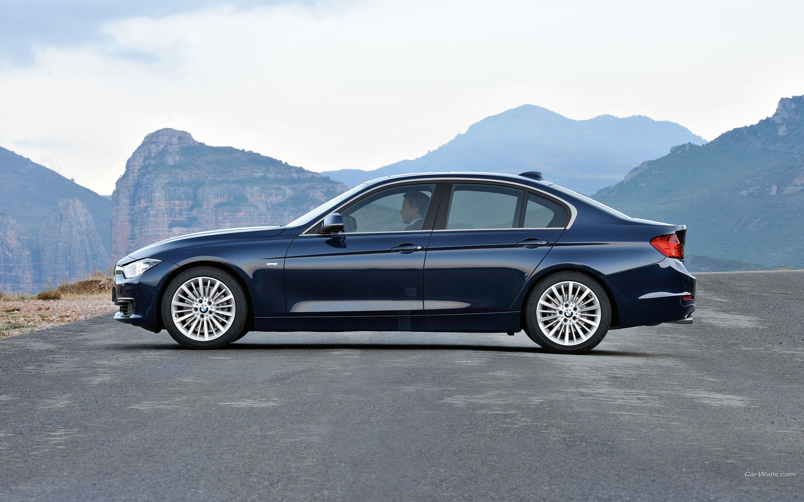 blue bmw sedan on mountain road