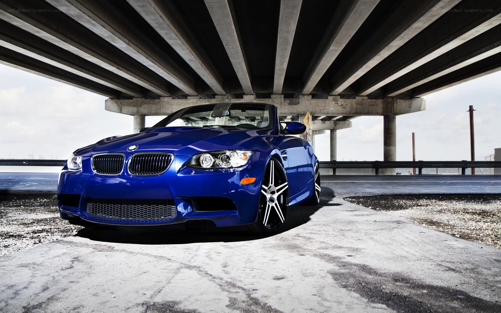 Blue BMW under a bridge