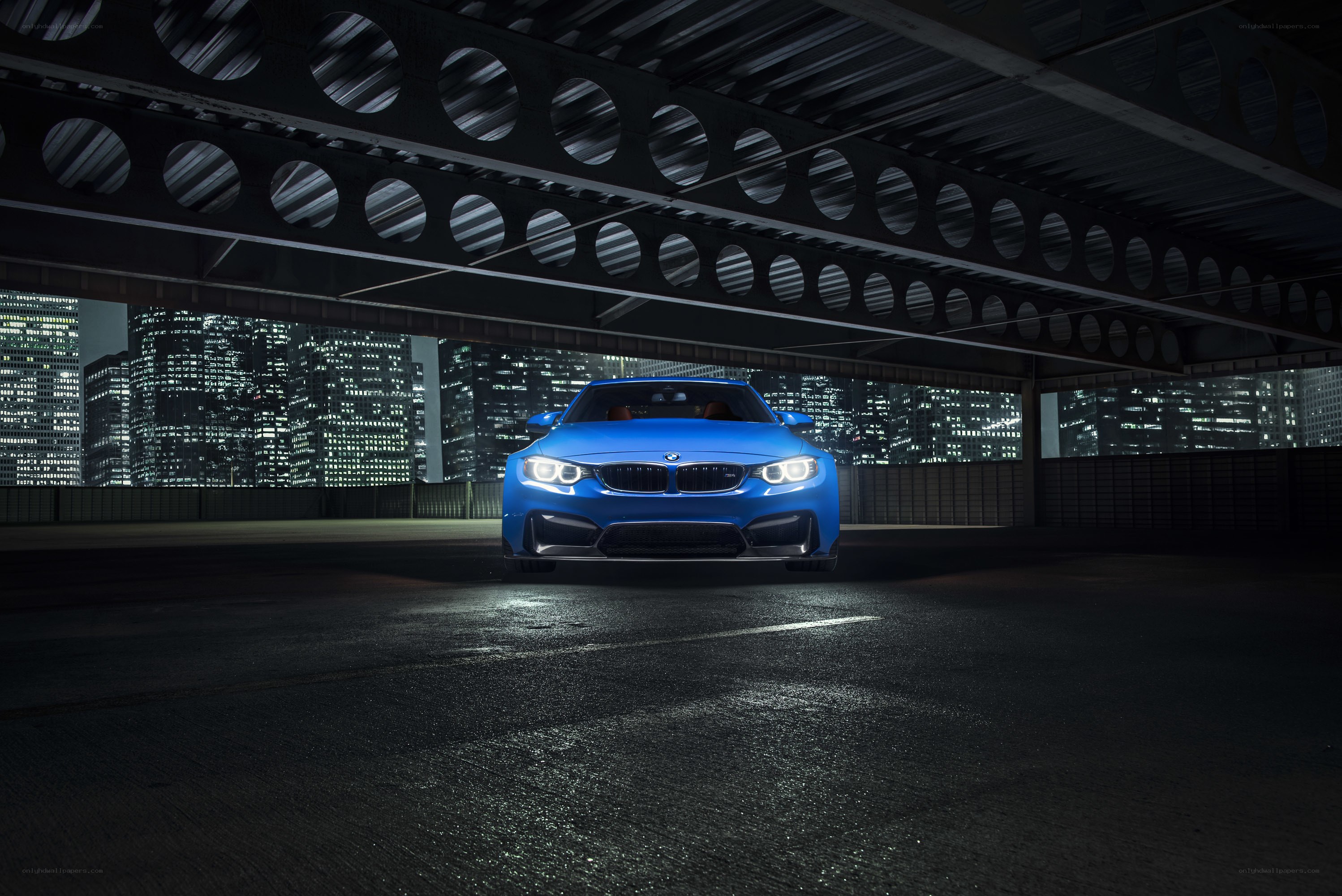 Blue BMW under bridge at night