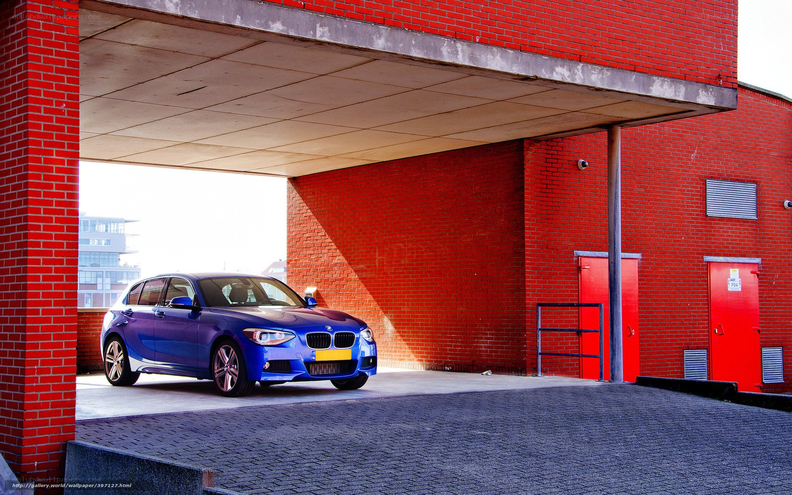 Blue BMW under red brick overhang