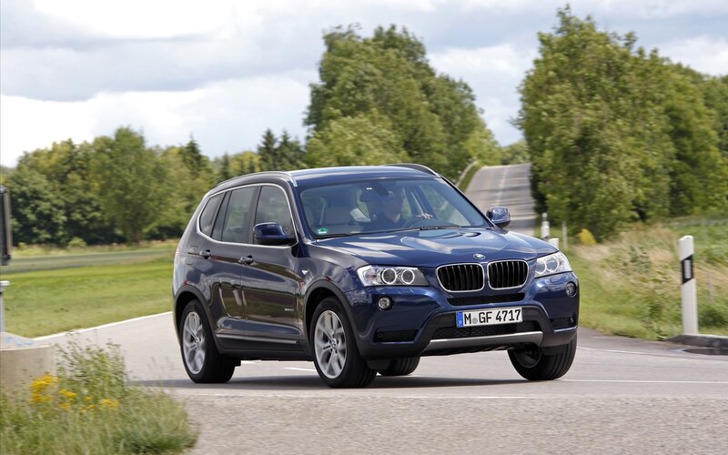 Blue BMW X3 on a country road