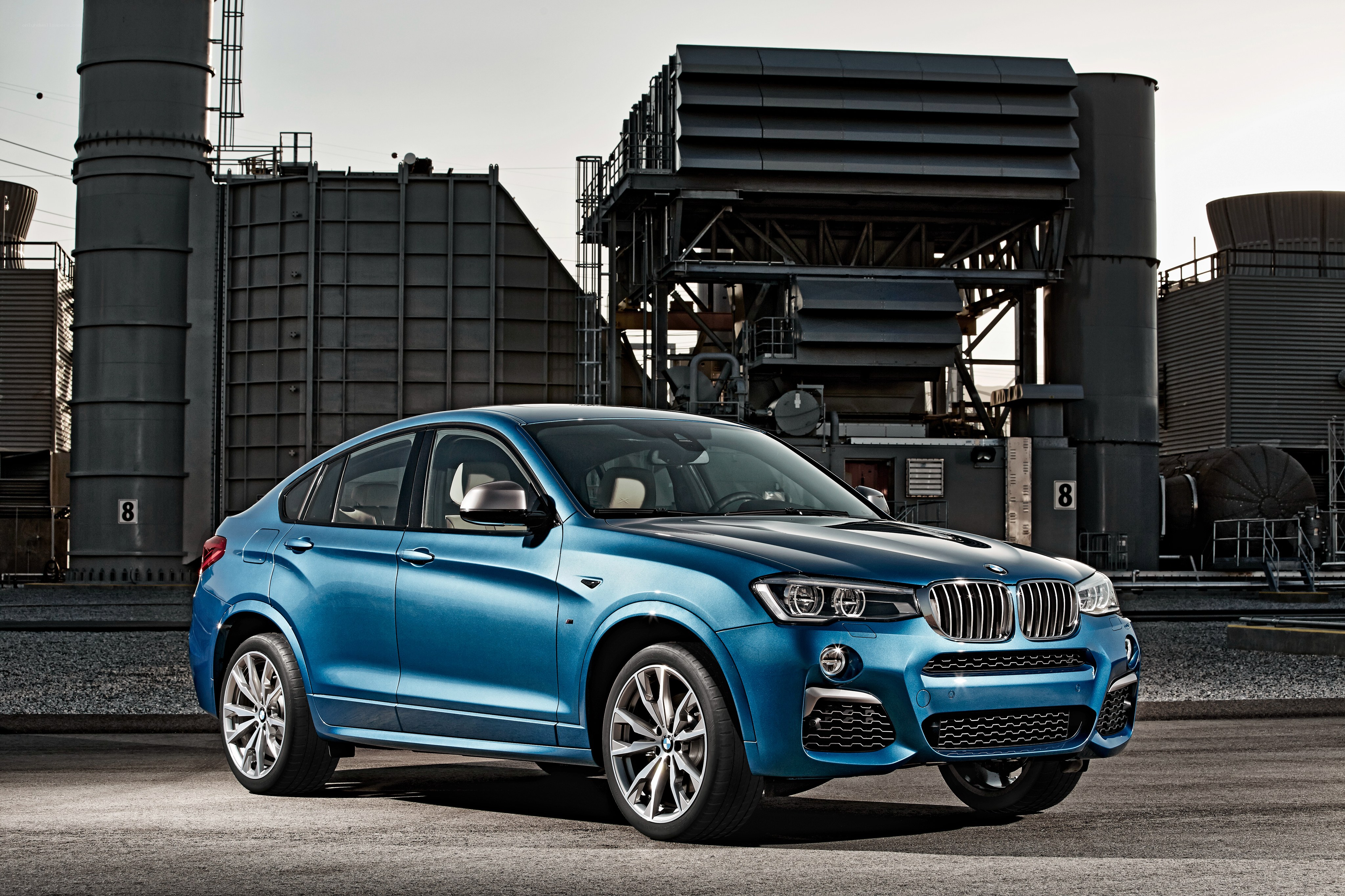 Blue BMW X4 in industrial setting