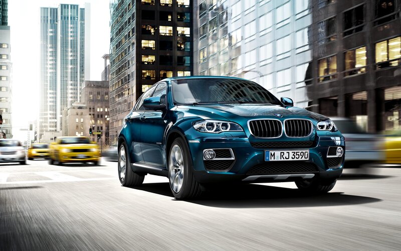 Blue BMW X6 in city traffic