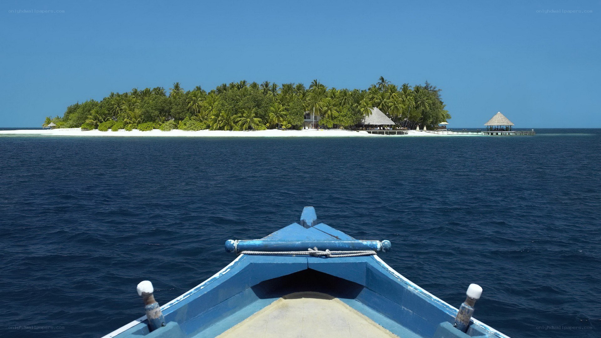 blue boat approaching tropical island