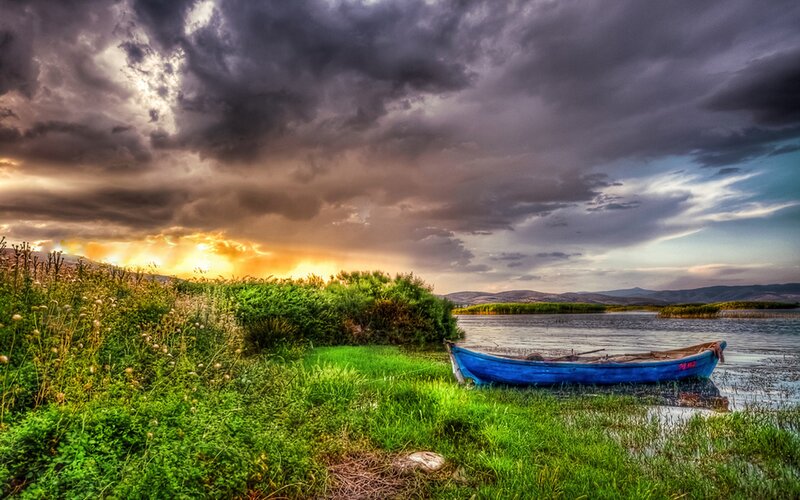 Blue boat at sunset by the lake