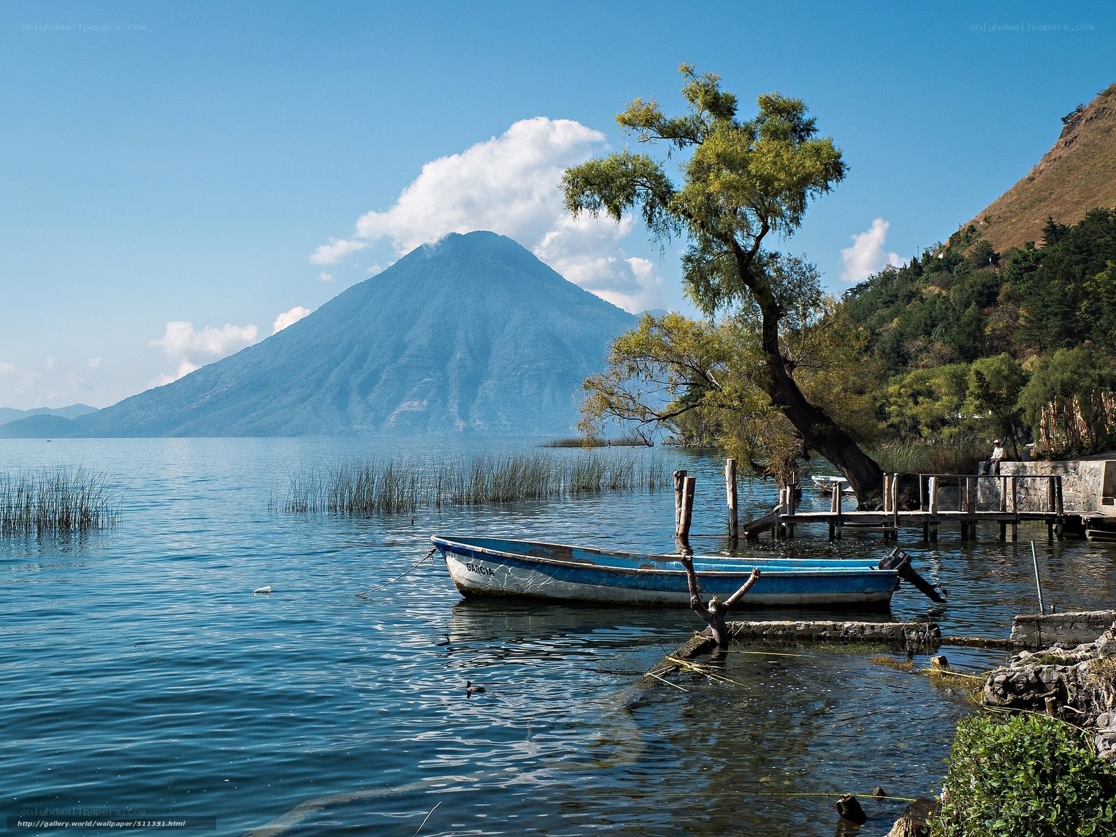 Blue boat by a lake with volcano