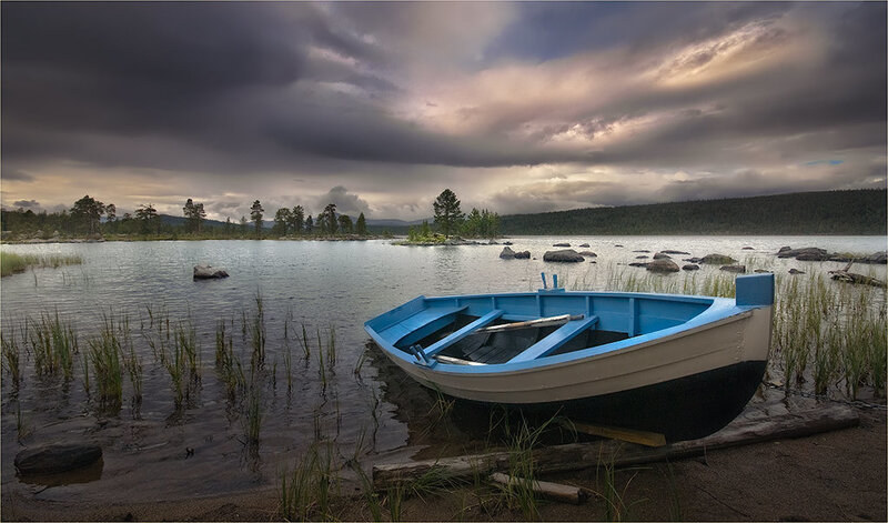 Blue boat on a lake at dusk