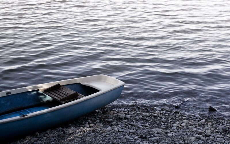 Blue boat on pebble shore