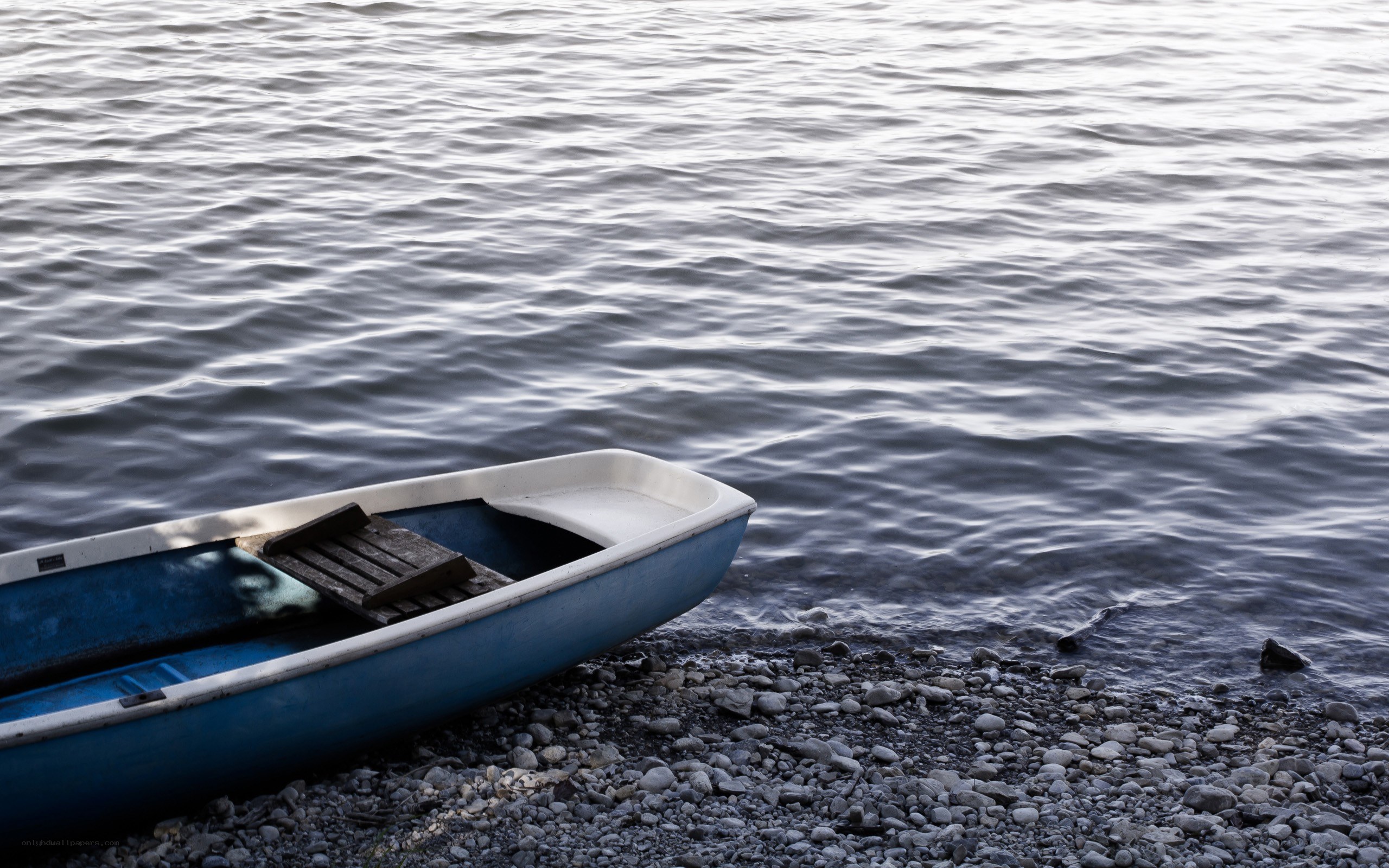 Blue boat on pebble shore