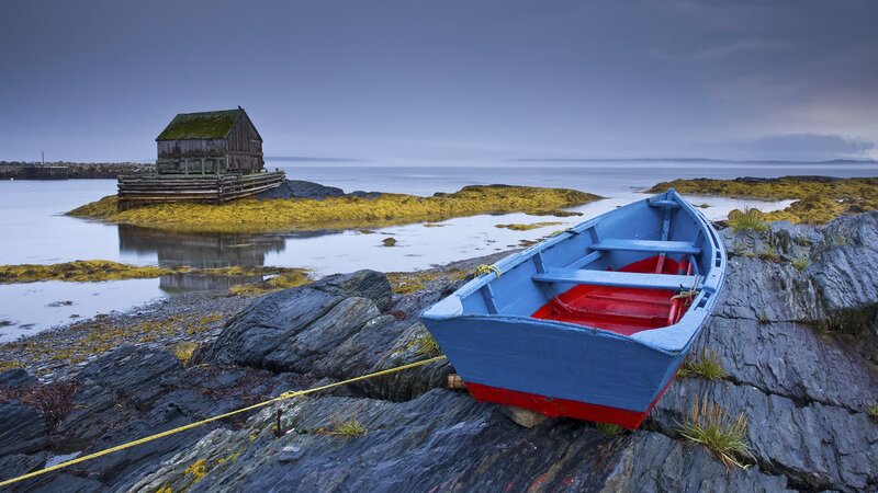 Blue boat on rocky shore