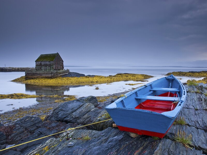 Blue boat on rocky shore