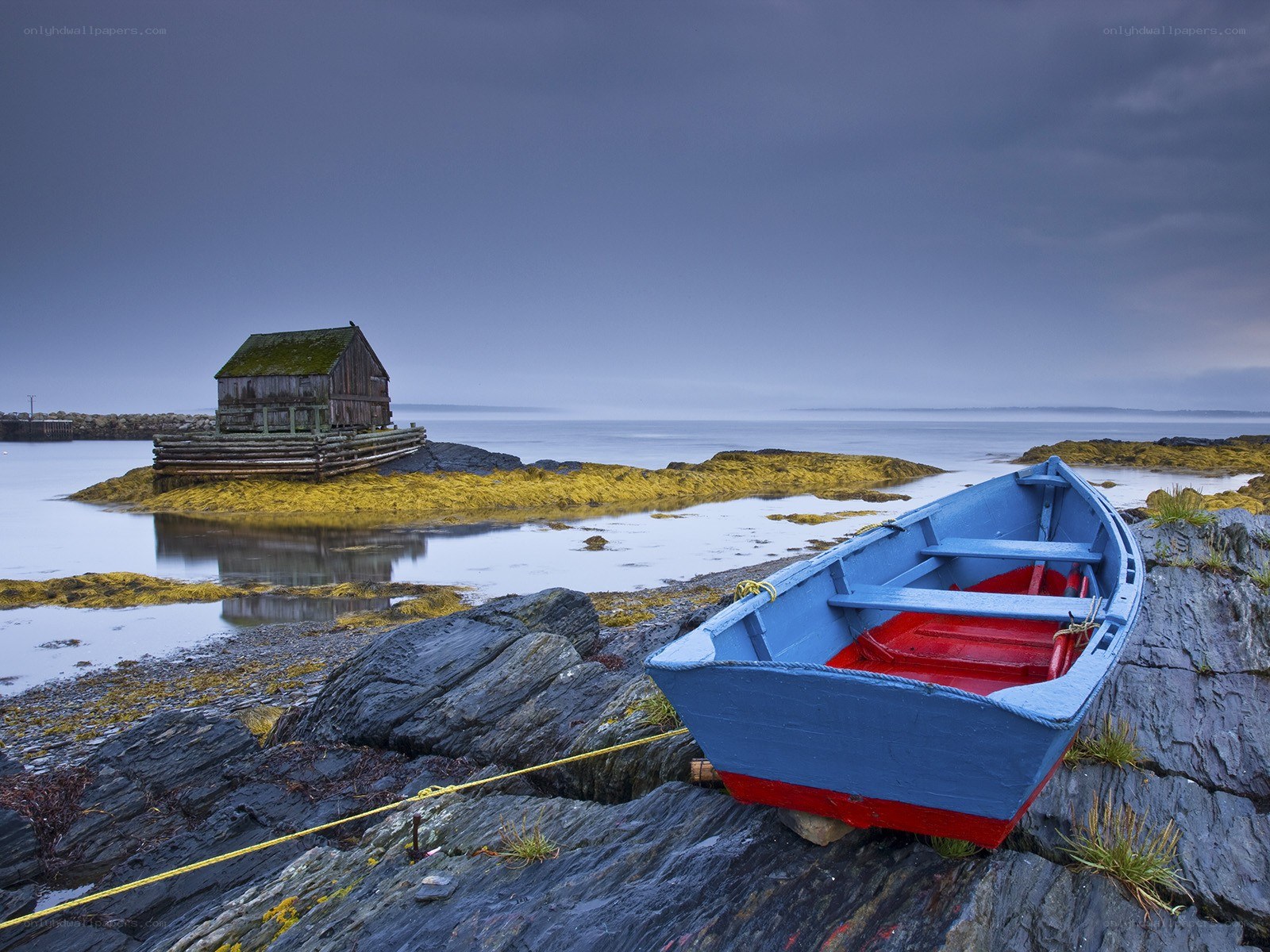 Blue boat on rocky shore