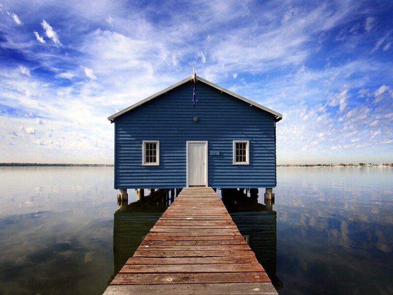 Blue boathouse on a calm lake