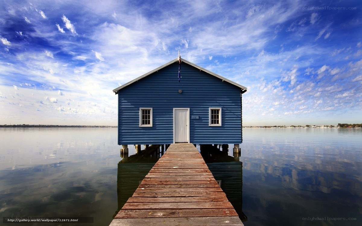 Blue boathouse on calm water