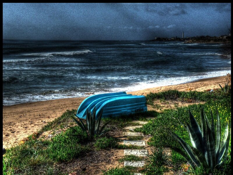 Blue boats on a stormy beach