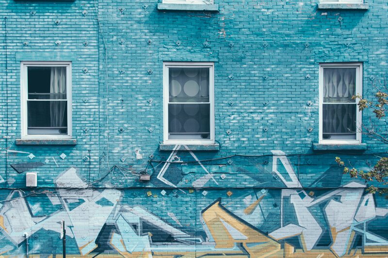 blue brick building with graffiti
