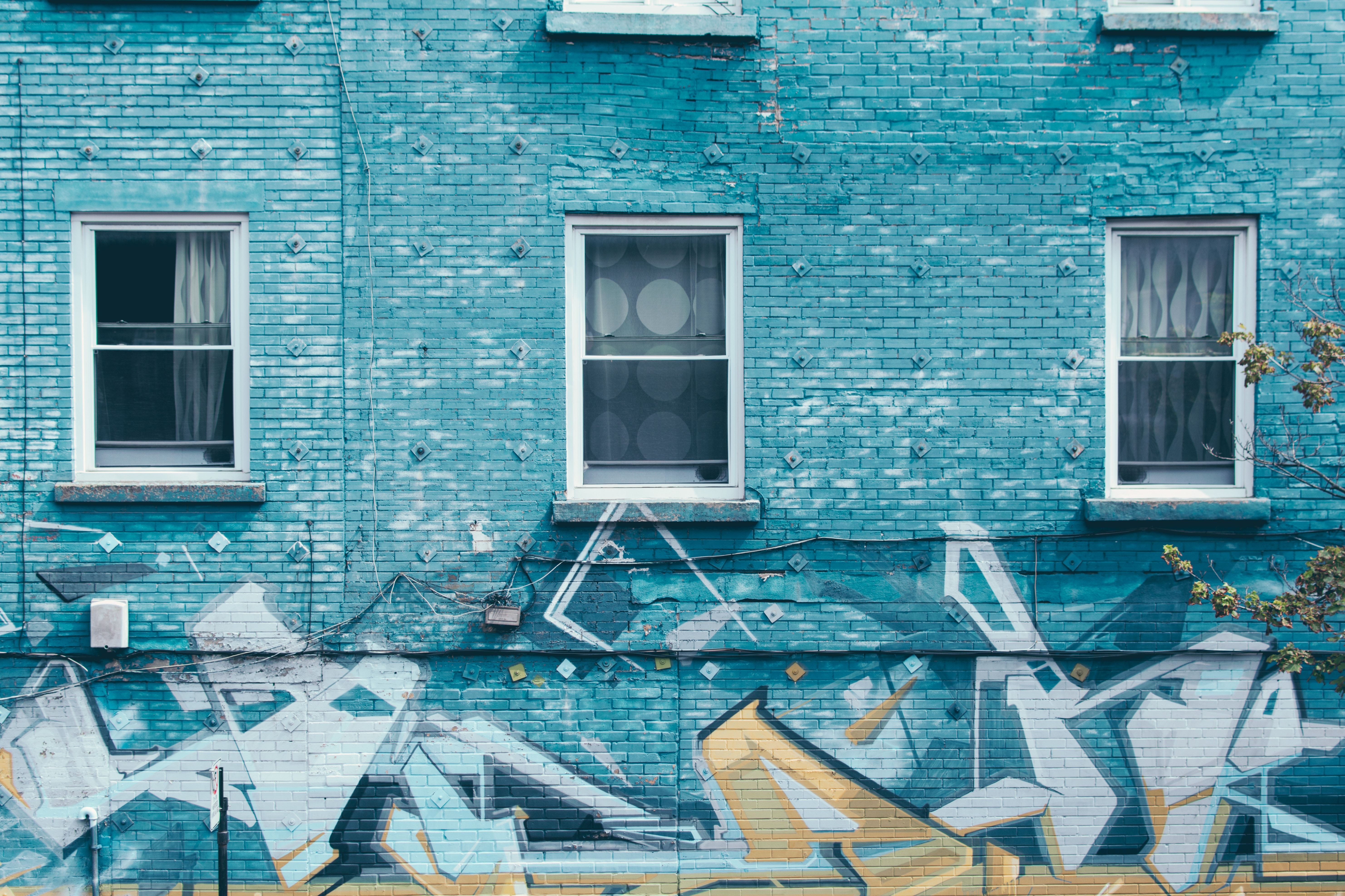 blue brick building with graffiti