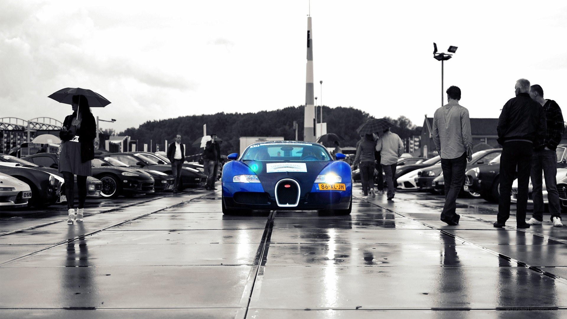 Blue Bugatti on wet pavement