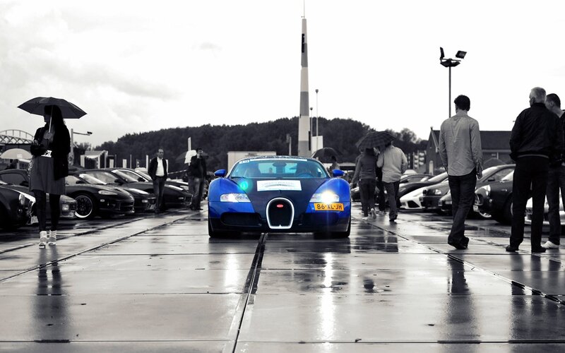 Blue Bugatti on wet pavement